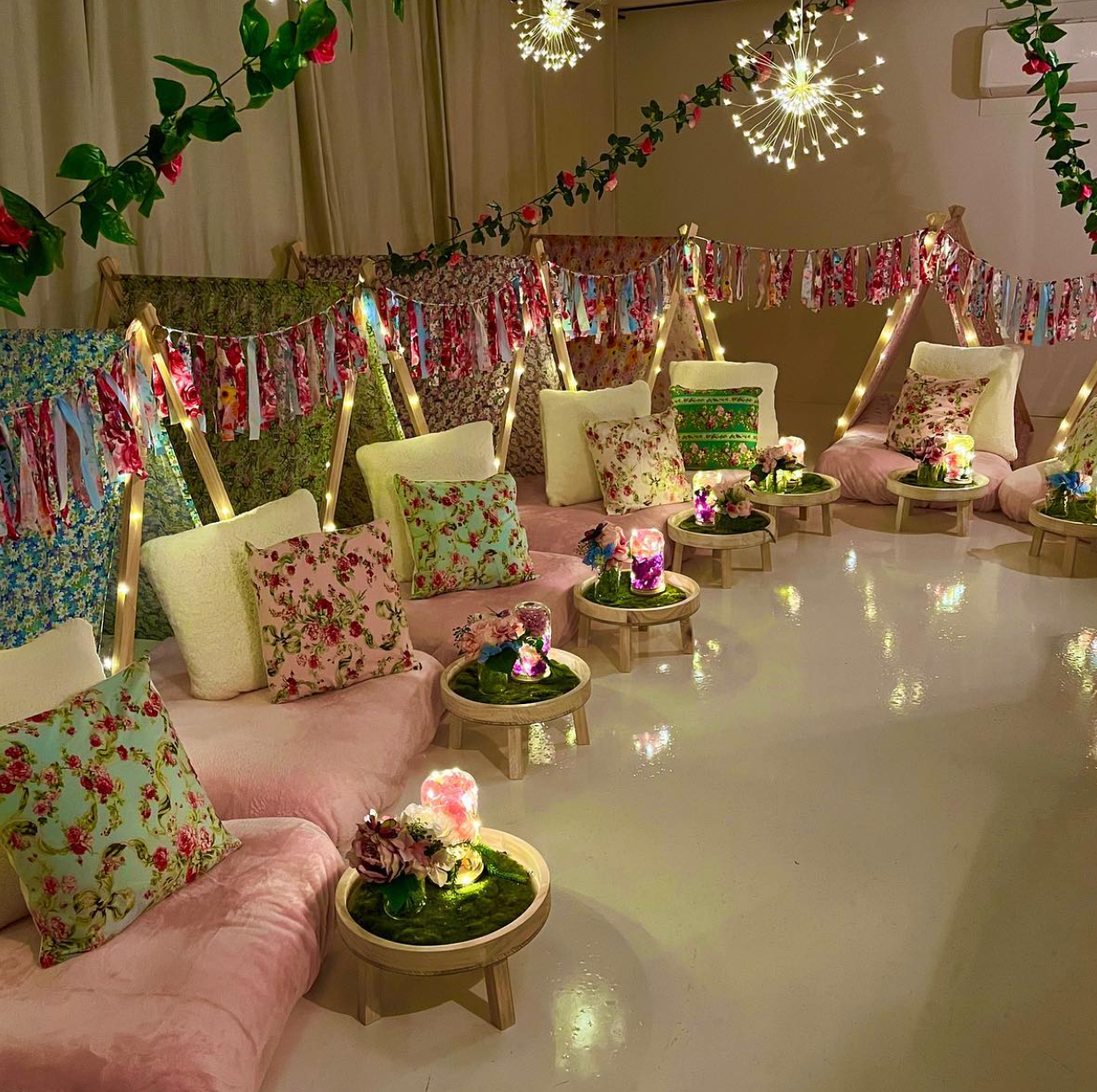 Six (6) colourful cute teepees with bunting, pink blanket, and twinkle lights set up for a luxury indoor slumber party in Melbourne