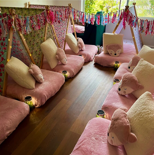 Eight (8) colourful cute teepees with bunting, pink blanket, and twinkle lights set up for a luxury indoor slumber party in Melbourne
