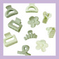 Kids assorted hair clips in colour light green/sage. Designs include flower, claw clip, swirl pattern, etc.